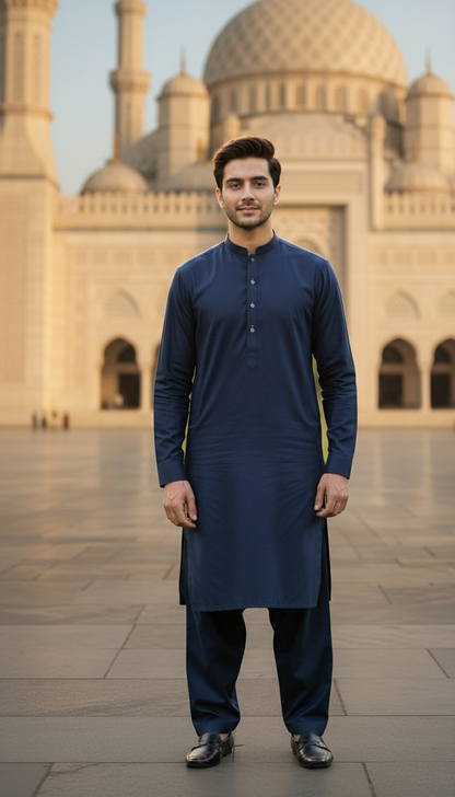 Man wearing a navy blue pasha cotton kurta standing in front of a mosque.