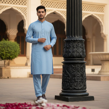Man in a sky blue pasha cotton kurta standing in an ornate architectural setting