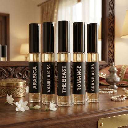 Five perfume bottles labeled 'Arabica', 'Vanilla Kiss', 'The Beast', 'Romance', and 'Grand Aura' on a wooden surface.
