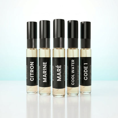Five small perfume bottles with black labels on a light background